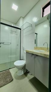 a bathroom with a toilet and a glass shower at Studio Flat Tramonto in João Pessoa +9 photos