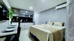 a bedroom with a bed and a table in it at Studio Flat Tramonto in João Pessoa