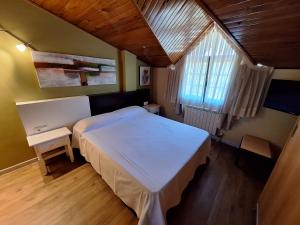 sypialnia z dużym białym łóżkiem i oknem w obiekcie Hostal O Galeón San Luis w mieście Moaña
