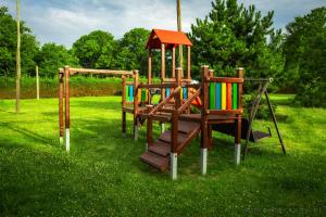 a set of playground equipment in the grass at Agroturystyka Spokojna domek 5 osobowy in Pogorzelica