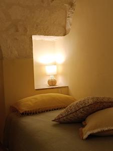 a bedroom with a bed with a lamp on it at Trullo Galeotto in Martina Franca