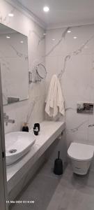 a white bathroom with a sink and a toilet at Aegean Sun Hotel in Skala Rachoniou