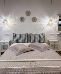 a bedroom with a bed with two tables and two lights at Afroditi's House studioB4 in Ormos Panagias