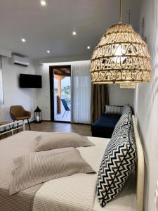 a bedroom with two beds and a chandelier at Afroditi's House studioB4 in Ormos Panagias +9 photos