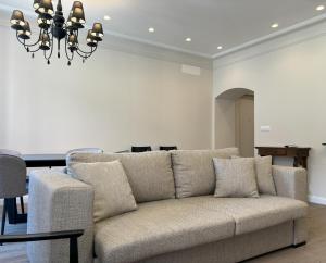 a living room with a couch and a chandelier at Il Sogno Apartment in Trieste