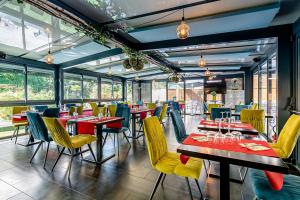 un restaurant avec des tables, des chaises et des fenêtres dans l'établissement Camping Domaine Les Oréades - Maeva Sélection, à Sanguinet