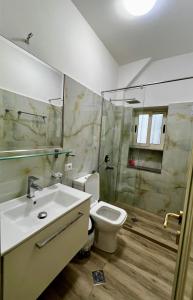 een badkamer met een wastafel, een toilet en een douche bij Le Monde 2 in Borsh