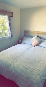 a bedroom with a bed with two pillows and a window at Lakeside East 16 - Haggerston Castle in Berwick-Upon-Tweed +12 photos