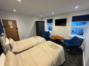 a bedroom with two beds and a table and chairs at Ashfield Guesthouse in Douglas