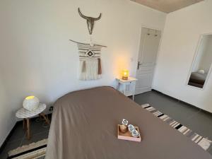 une chambre avec un lit avec un livre dessus dans l'établissement La Cabane aux lacs ~ Maison cosy au calme, à Aureilhan