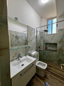 een badkamer met een wastafel en een toilet bij Le Monde 2 in Borsh
