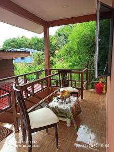 a porch with a table and chairs on it at Teratak Yoi in Pantai Cenang +10 photos