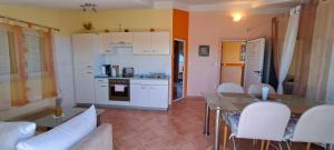 a kitchen with white cabinets and a table and chairs at Apartments Villa Bella Vista Hvar in Hvar
