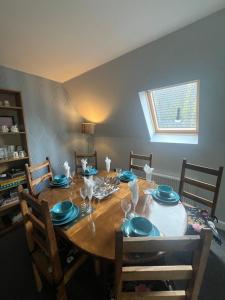 una mesa de comedor con platos azules y vasos. en Pheasant lodge - Balmaha 3 bed en Glasgow