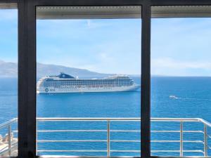 a cruise ship in the ocean viewed from a window at Belle View Apartment in Sarandë