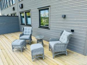 a patio with wicker chairs and chairs and a table at Ny og moderne studio leilighet ! in Fetsund