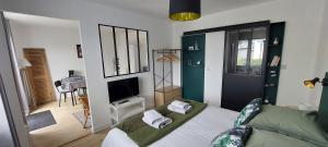 1 dormitorio con 1 cama y TV. en CHAMBRE AVEC SUITE DE 26 M2, en Saint-Planchers