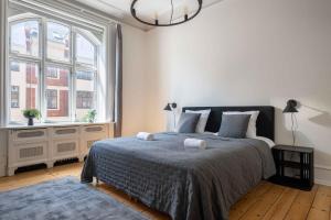 a bedroom with a bed and a large window at Lovely 3BR Manor Flat 5 min from Tivoli Gardens in Copenhagen