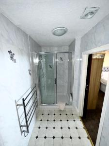 y baño con ducha y puerta de cristal. en Ashfield Guesthouse, en Douglas