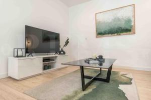 uma sala de estar com uma televisão e uma mesa de centro em Peaceful retreat near the historic center by REMS em Málaga