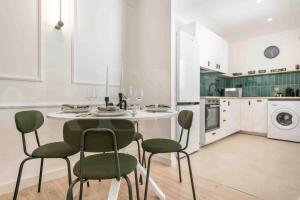 uma cozinha branca com uma mesa e cadeiras em Peaceful retreat near the historic center by REMS em Málaga