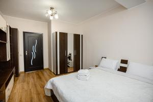 a white bedroom with a bed with towels on it at Retreat relaxant cu 2 dormitoare! in Chişinău