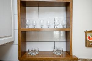 a row of glasses on a wooden shelf at Retreat relaxant cu 2 dormitoare! in Chişinău +14 photos