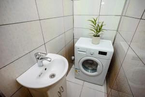 a bathroom with a sink and a washing machine at Retreat relaxant cu 2 dormitoare! in Chişinău