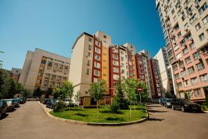 a group of tall buildings with cars parked in a parking lot at Retreat relaxant cu 2 dormitoare! in Chişinău
