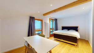 a bedroom with a bed and a table in it at Chalet de l Ours in Agettes