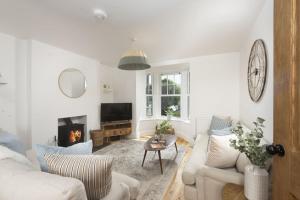 a living room with a couch and a fireplace at 11 Tywarnhayle House, Perranporth in Perranporth