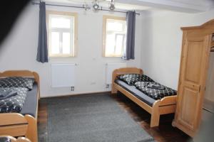 two beds in a room with two windows at Castillo in Ensheim
