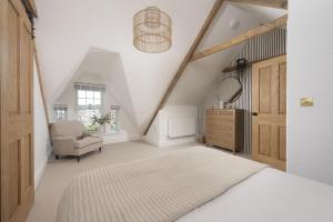 a bedroom with a bed and a chair and a mirror at 11 Tywarnhayle House, Perranporth in Perranporth