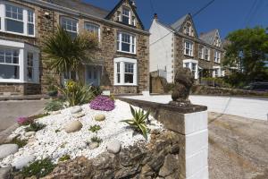 a house with a statue in the front yard at 11 Tywarnhayle House, Perranporth in Perranporth