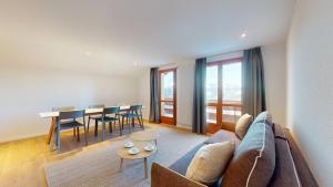 ein Wohnzimmer mit Couch und Tisch in der Unterkunft Chalet de l Ours VUE & NATURE Appart Pregny 8 pers in Agettes