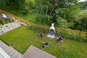 eine Luftansicht auf einen Garten mit Stühlen und einem Kamin in der Unterkunft Domki u Sosny in Brenna