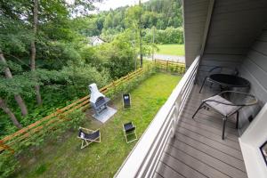 einen Balkon mit einem Tisch und Stühlen auf dem Rasen in der Unterkunft Domki u Sosny in Brenna