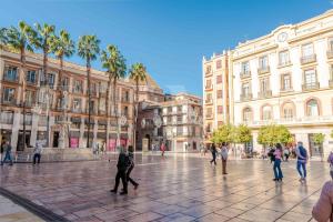 um grupo de pessoas andando em torno de uma praça da cidade em Peaceful retreat near the historic center by REMS em Málaga