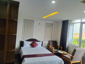 ein Hotelzimmer mit einem Bett, Stühlen und einem Fenster in der Unterkunft Tuệ Tĩnh Tower 21 in Nha Trang