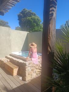 a girl in a hat sitting in a hot tub at Hôtel Les Suites Du Maquis in Bonifacio