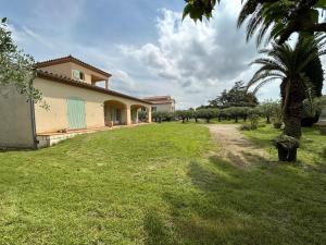 a house with a palm tree in the yard at Villa Les Oliviers in Orange