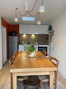 a dining room table with chairs and a kitchen at Maison côté halle " Le Parc" in Saint-Flour