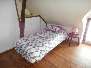 Un dormitorio con una cama y una mesa con una lámpara. en La Gentilliere, en Brunelles