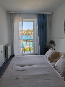 um quarto com uma cama grande e uma janela grande em Hotel Dalmacija em Vela Luka