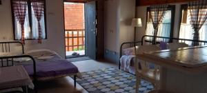 a room with beds and a table and windows at Garičkina kuća 2 in Pirot