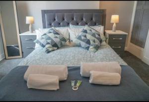 a bedroom with a bed with two towels and two lamps at Beautiful Home near City Centre in Nottingham
