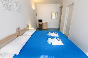 a bedroom with a blue bed with towels on it at Villa Tre Mari in Villasimius