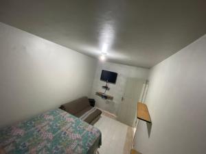 1 dormitorio con 1 cama y 1 sofá en una habitación en Casa de praia Suarão Beach, en Itanhaém