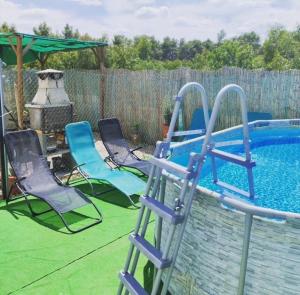 a group of chairs sitting next to a swimming pool at La Casa de La Veleta Naturaleza y Calma in La Rinconada de Tajo