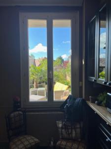 ventana en una cocina con vistas a una casa en Maison Menadel, en Yvetot
